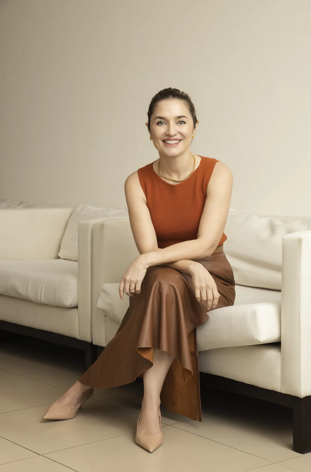 Dra. Daiane Saldanha sentada no sofá da clínica